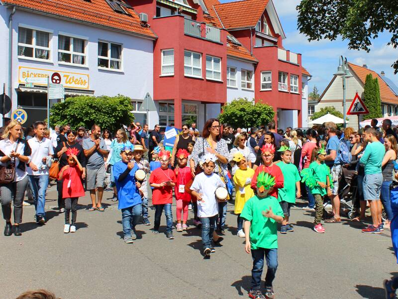 Eine fröhliche Gruppe von Kindern und Erwachsenen versammelt sich bei einem Umzug in Uhingen im Jahr 2018.