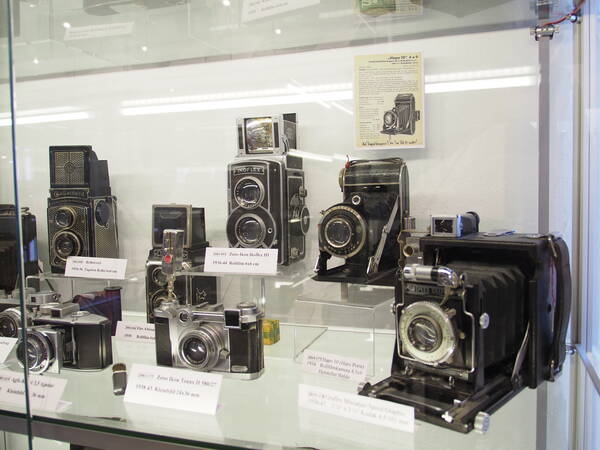 In einer beleuchteten Vitrine stehen mehrere Fotoapparate, die den Wandel der analogen Fotografie nachempfinden sollen.