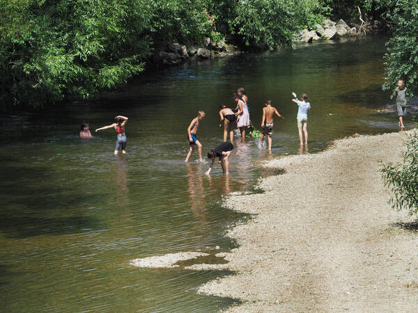 Planschende Kinder im Sommer im Fluss Fils.