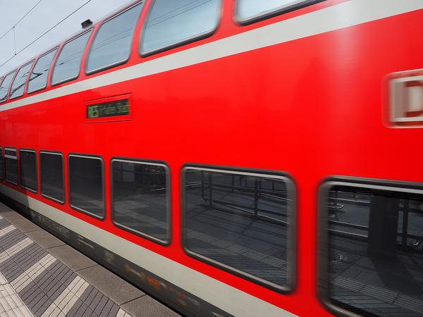 Ein einfahrender roter Zug im Bahnof