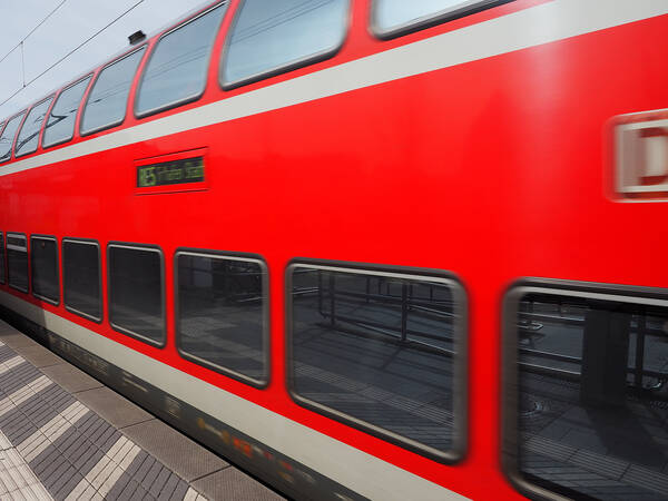 Ein einfahrender roter Zug im Bahnof