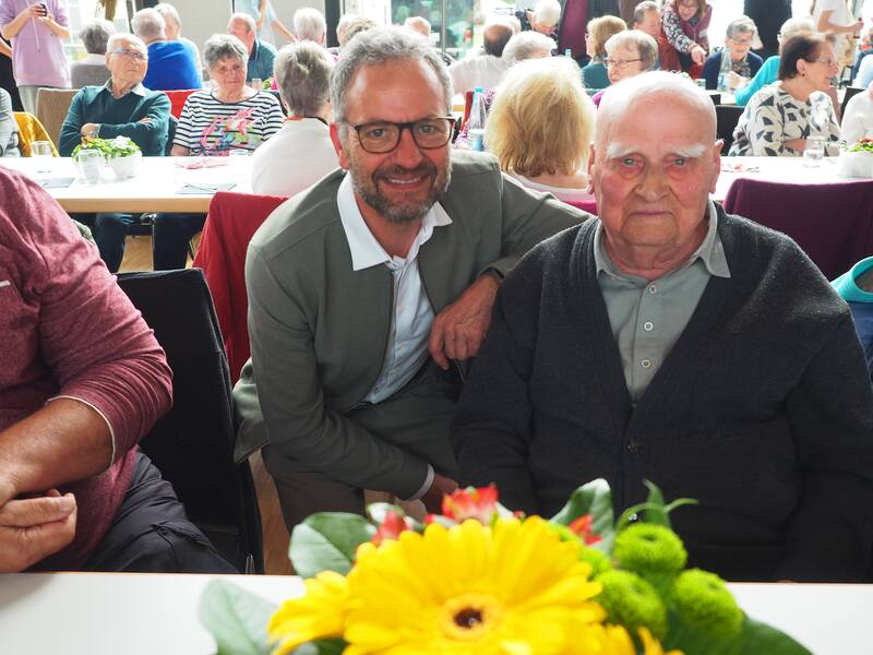 Bürgermeister Matthias Wittlinger ehrte den ältesten Besucher des Seniorennachmittags: den 98 Jahre alten Ludwig Lämmle. Vor ihm steht ein bunter Strauß auf dem Tisch.