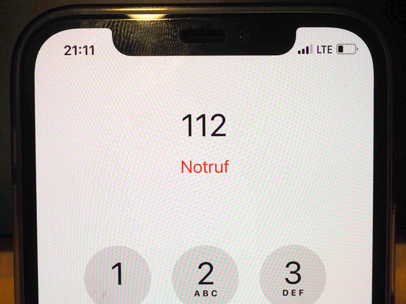 Auf dem Display eines Handy steht in roter Schrift "Notruf", darüber 112 und darunter in Kreisen die Zahlen von 1 bis 9.