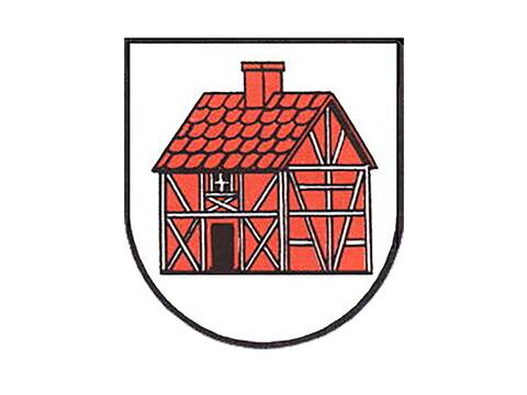 Das Wappen des Stadtteils Holzhausen ist wie ein Schild, das unten abgerundet ist. Darauf ist auf weißen Grund ein rotes Fachwerkhaus  mit weißen Balken, schwarzem Türeingang, darüber einem weißen Fensterkreuz und auf dem Dach mit roten Ziegeln und rotem Schornstein. 