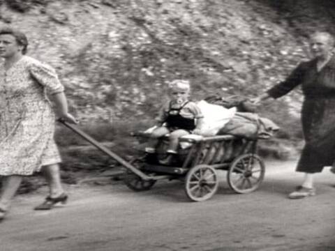 zwei Frauen mit einem Kind im Holzbollerwagen