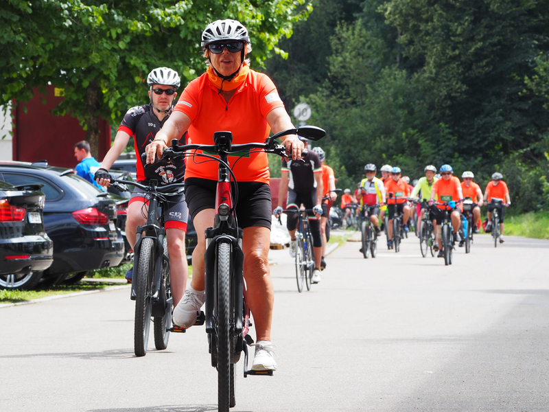 Mehrere Frauen und Männer fahren auf einer Straße Fahrrad.