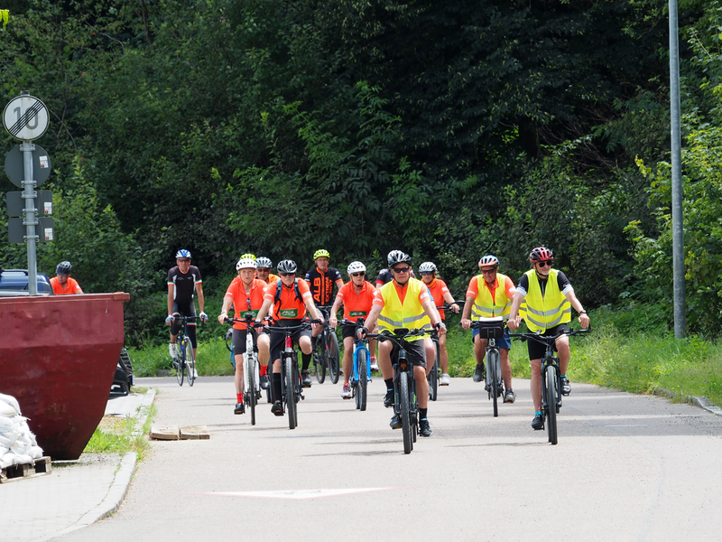 Mehrere Frauen und Männer fahren auf einer Straße Fahrrad.