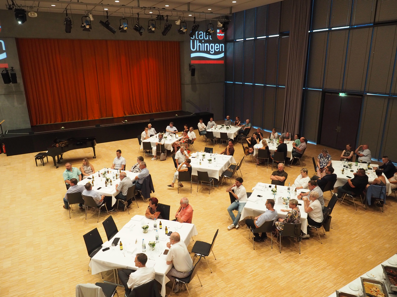 Im großen Saal des Uditorium stehen mehrere festlich geschmückte Tische, an denen Frauen und Männer sitzen.