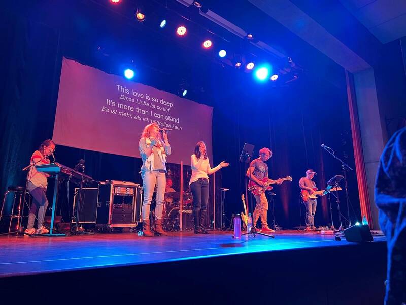 5 Personen auf der Bühne des Uditoriums die singen und ein Instrument spielen 