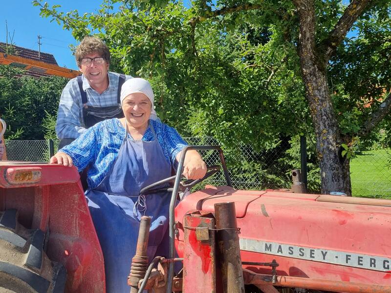 Ein Mann und eine Frau auf einem roten Traktor