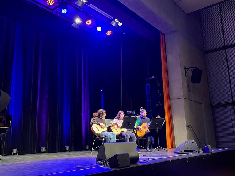 3 Musiker mit Instrumenten auf der Bühne im Uditorium