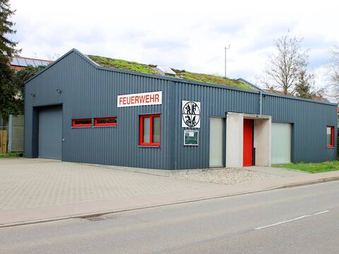 Das Gebäude der Feuerwehr im Stadtteil Holzhausen mit grauer Verkleidung und Fenstern mit rotem Rahmen.