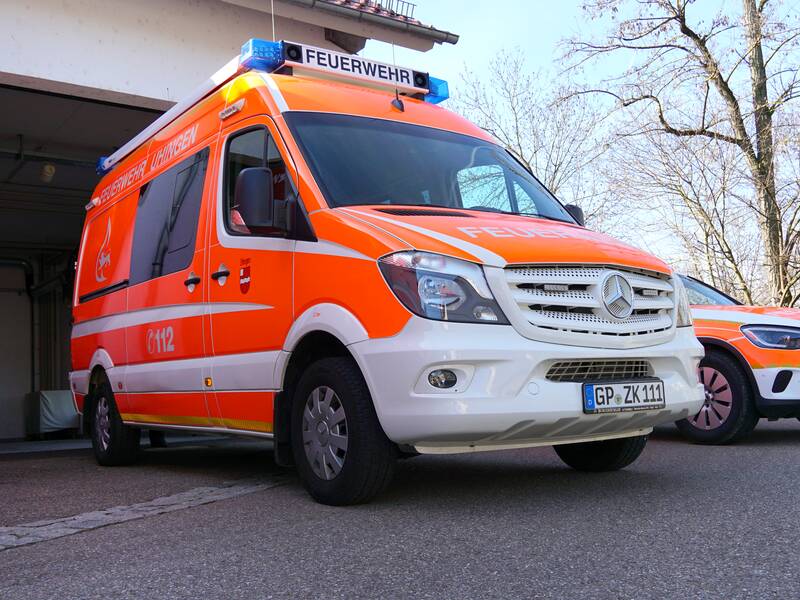 Der Einsatzleitwagen, kurz ELW, der Freiwilligen Feuerwehr in grellem Orange vor dem Feuerwehrmagazin.